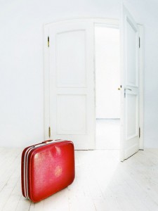 Suitcase in front of an open door --- Image by © Sagel & Kranefeld/Corbis